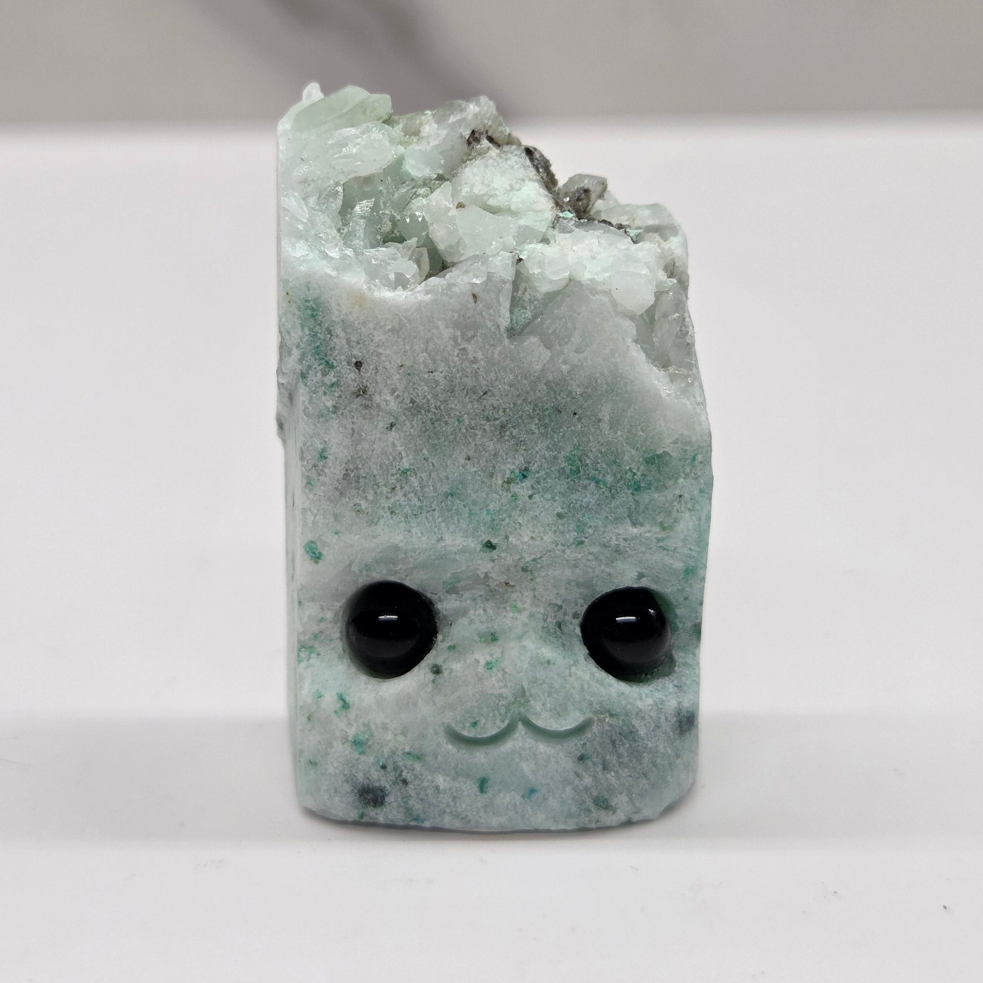 Phoenix Stone with eyes and a mouth on a white background