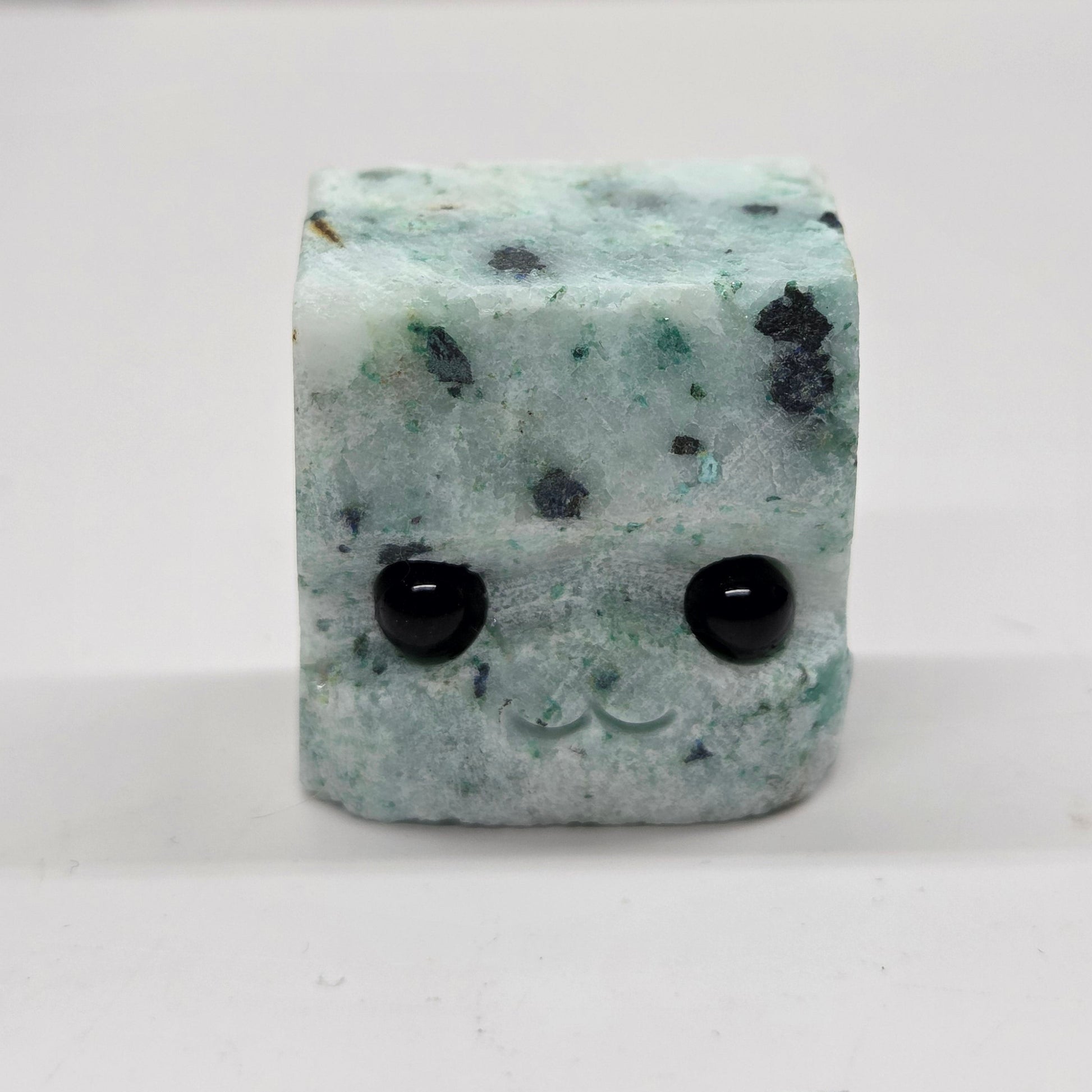 Phoenix Stone with eyes and a mouth on a white background