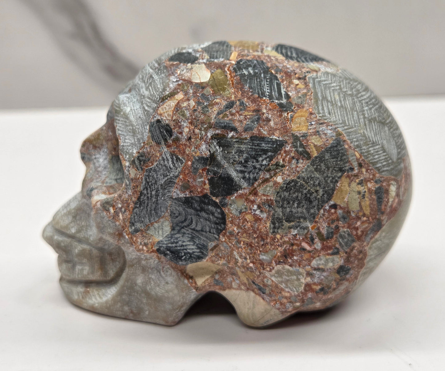 Decorative stone skull on a white surface with a neutral background