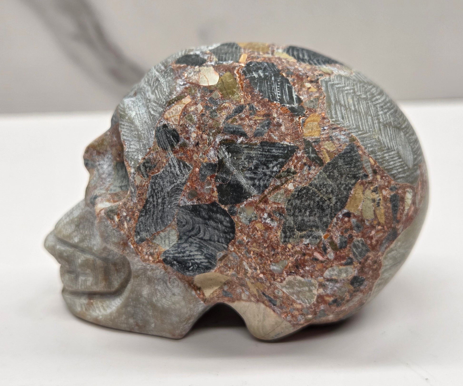 Decorative stone skull on a white surface with a neutral background