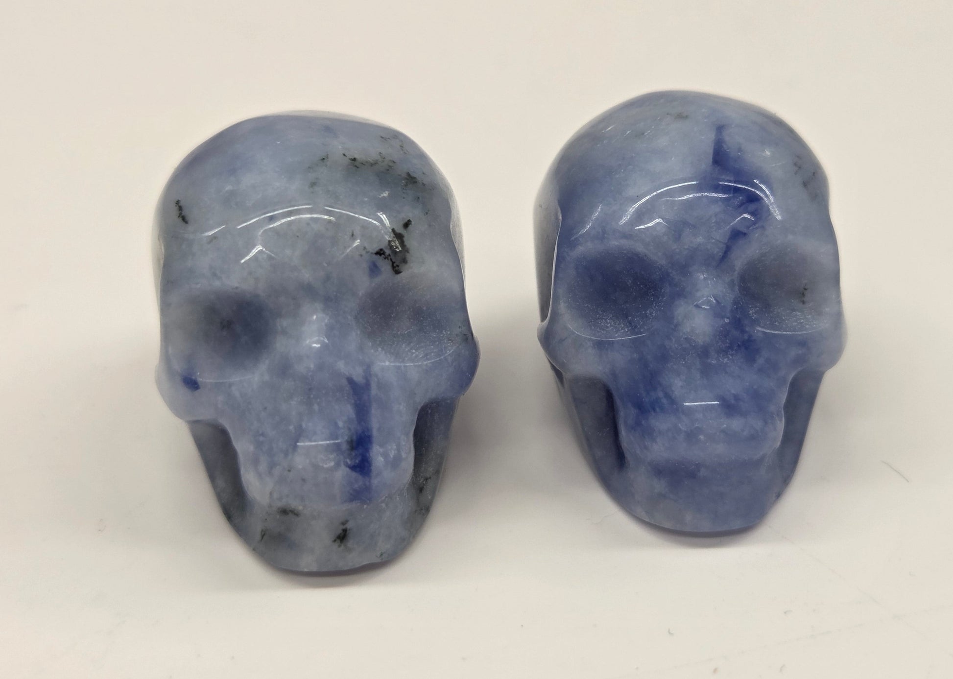 Two blue crystal skulls on a white background