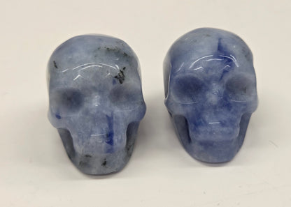 Two blue crystal skulls on a white background