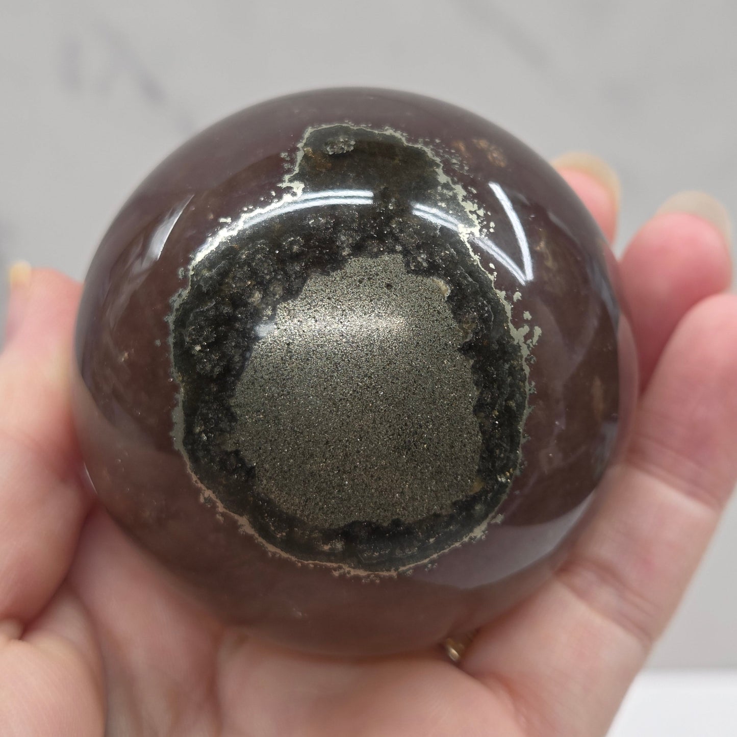 Hand holding a translucent sphere with a dark interior