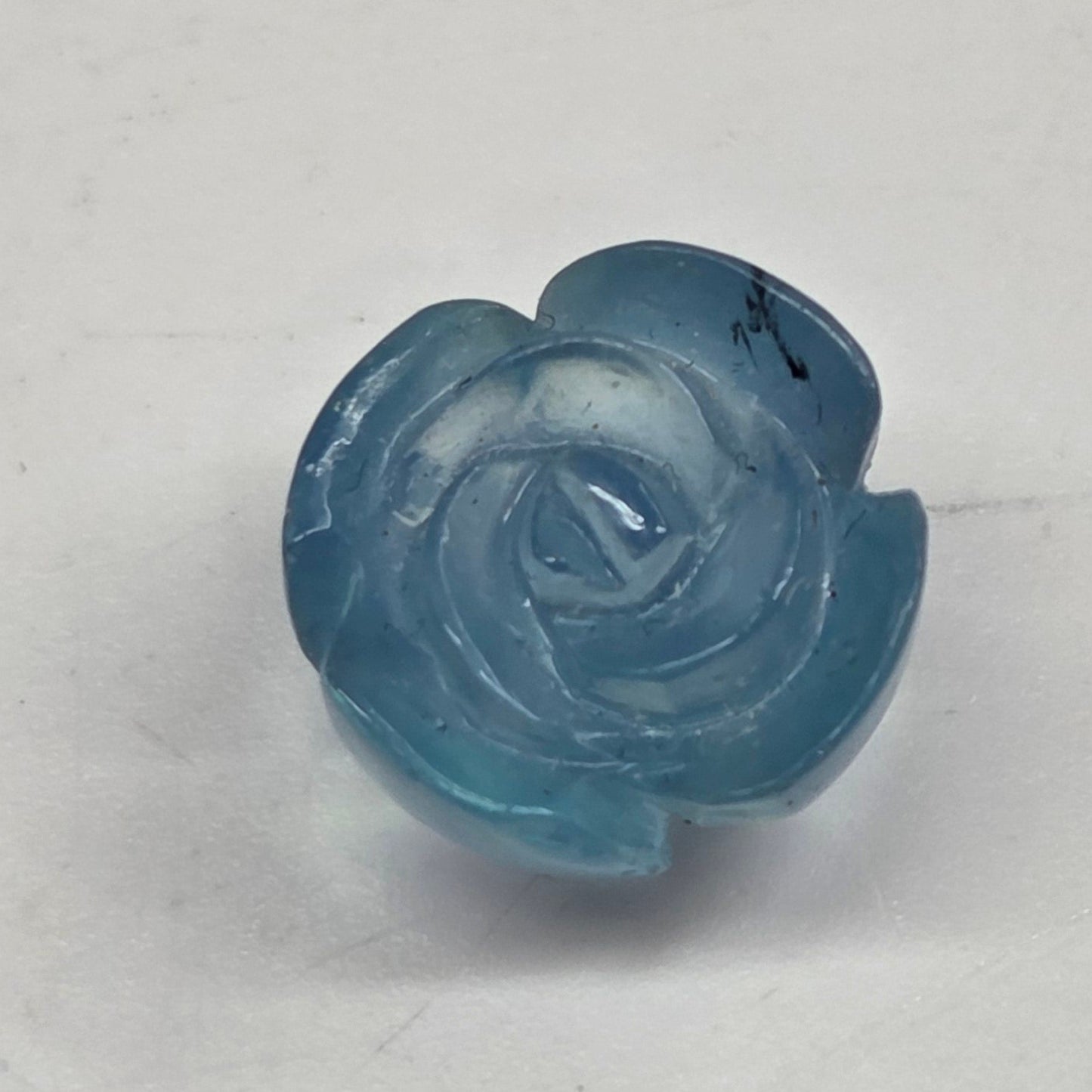 Blue rose-shaped object on a light gray background