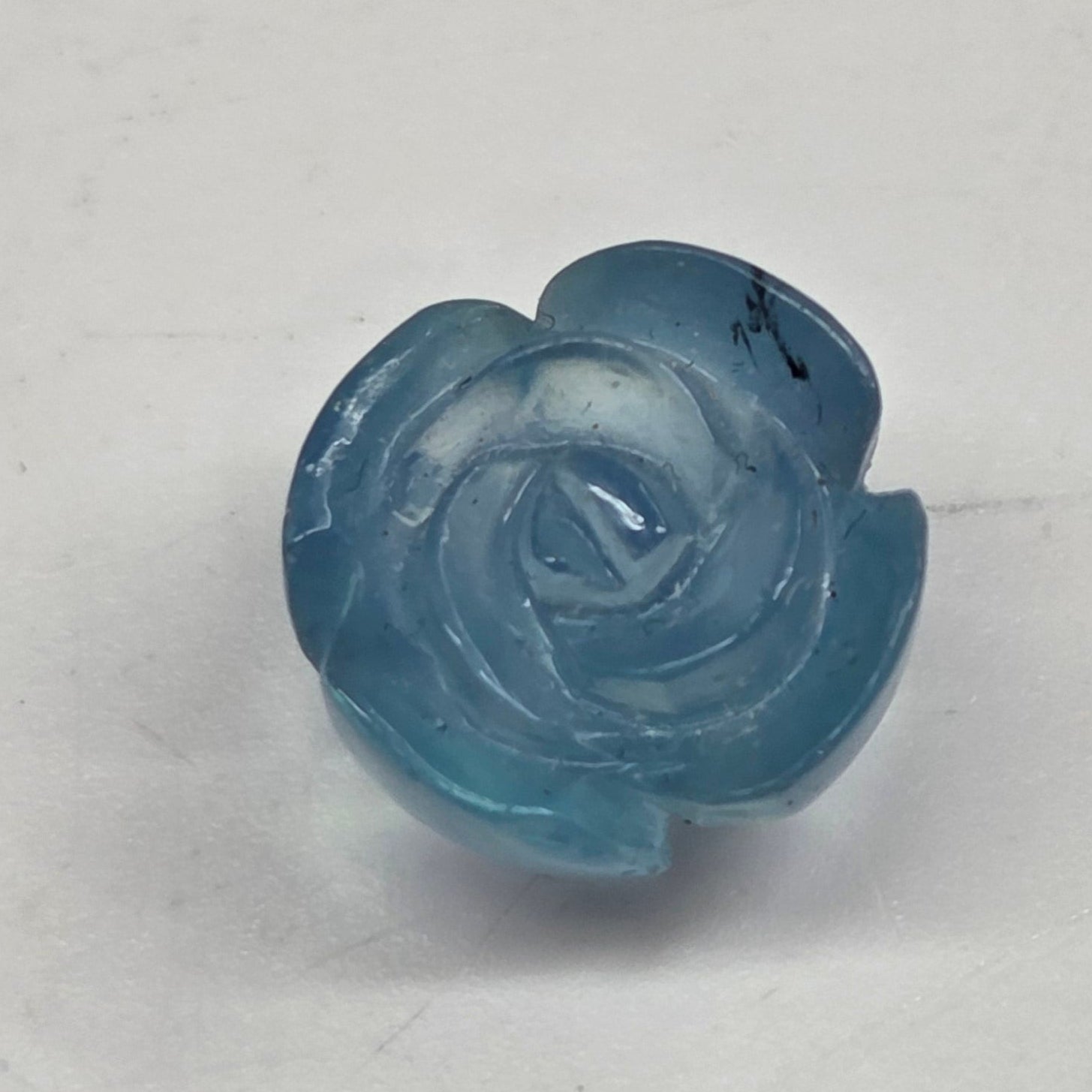 Blue rose-shaped object on a light gray background