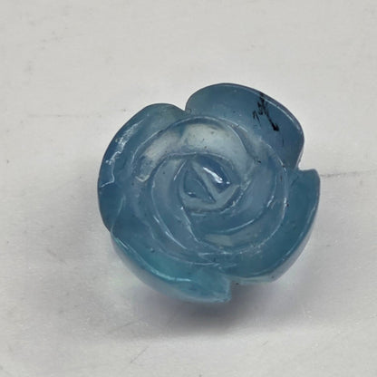 Blue rose-shaped object on a light gray background