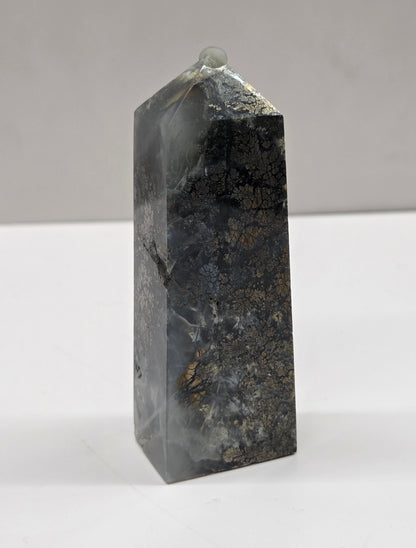Rectangular crystal on a white surface with a gray background