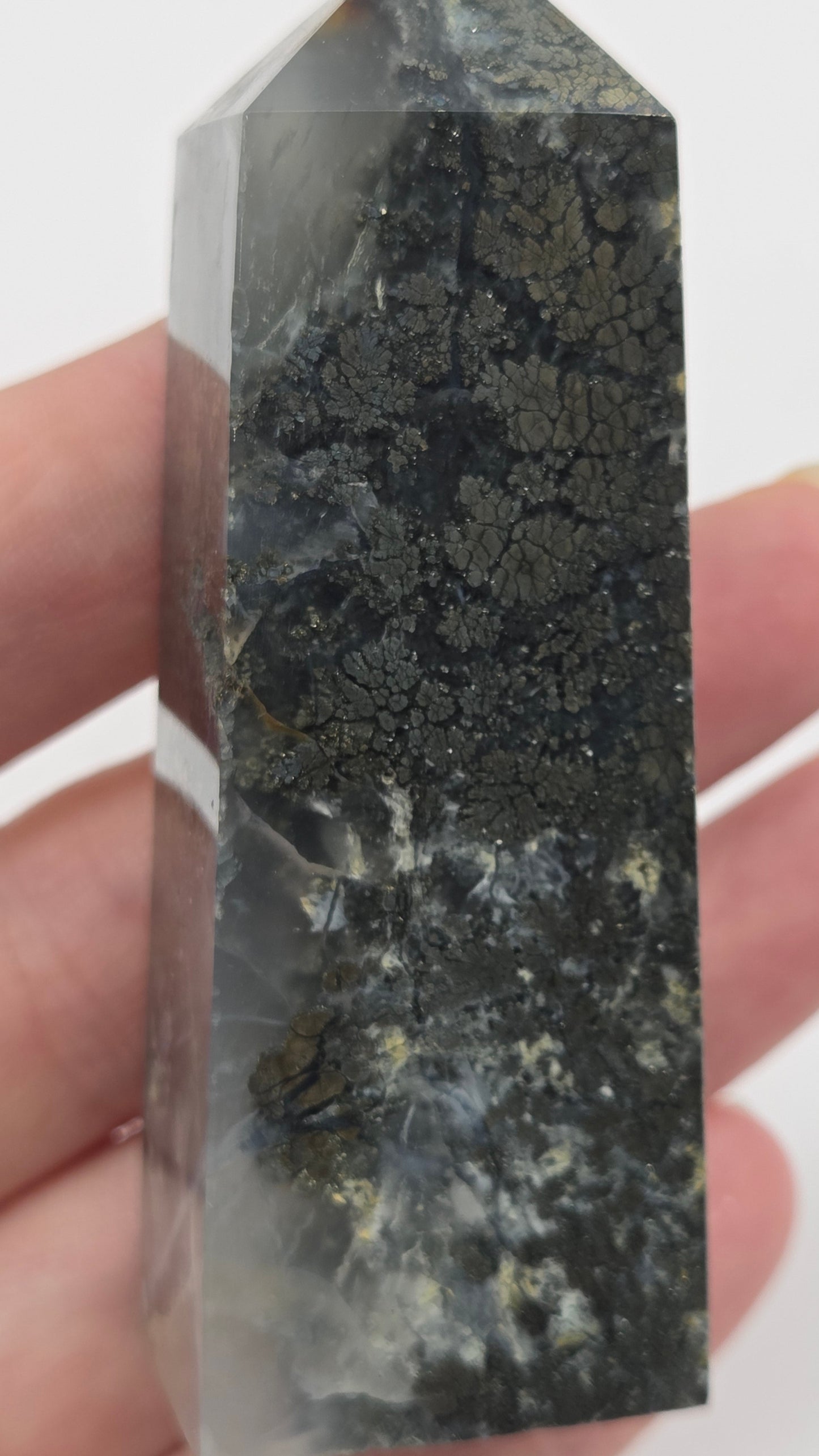 Crystal held in a hand against a white background