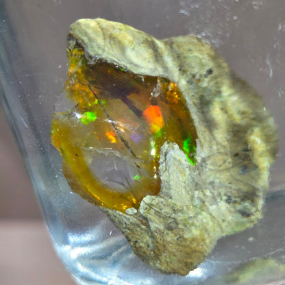 Mineral sample with colorful interior on a reflective surface