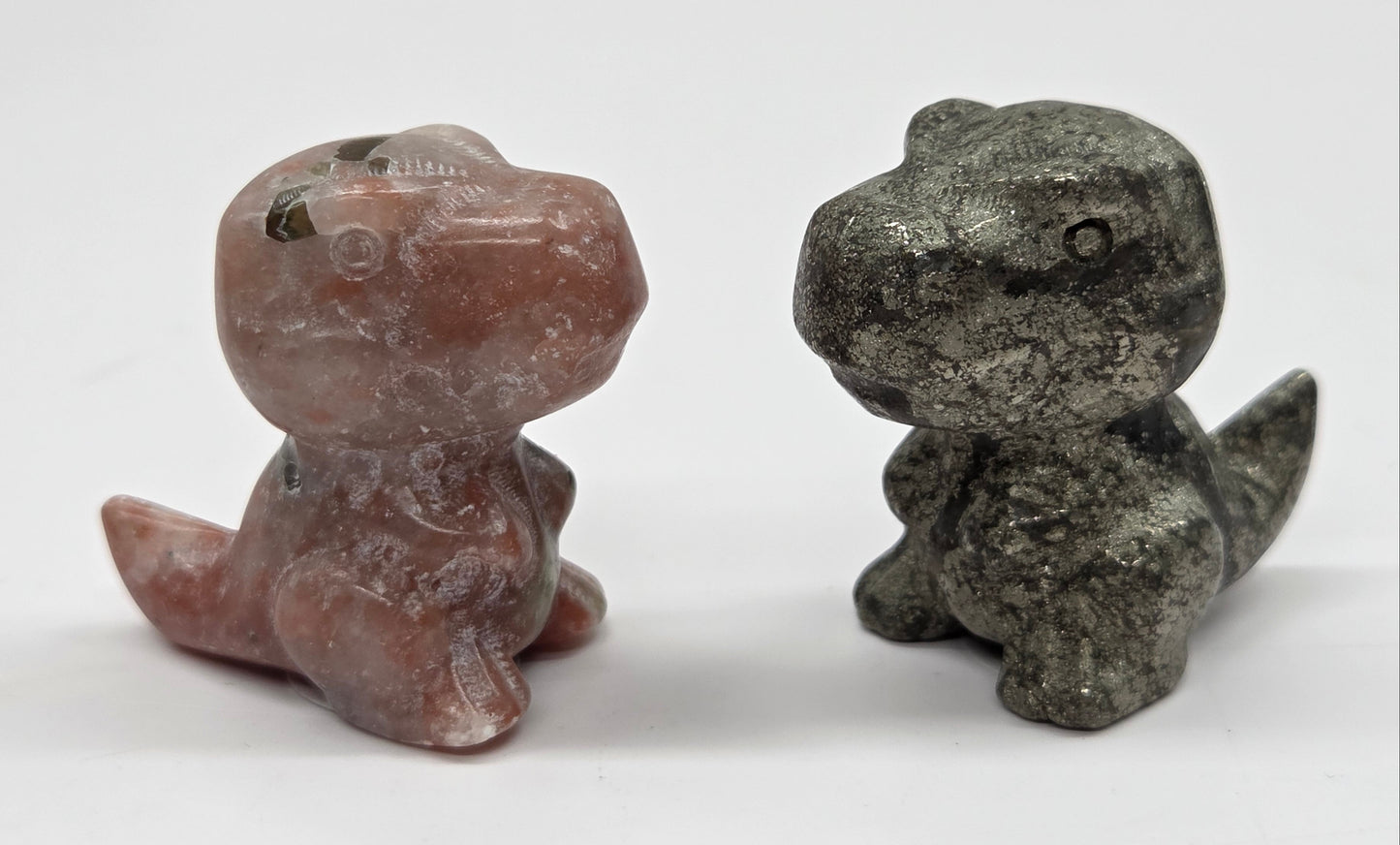 Two stone dinosaur figurines on a white background