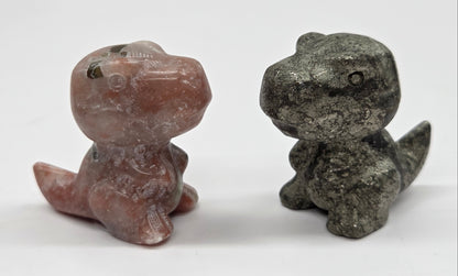 Two stone dinosaur figurines on a white background