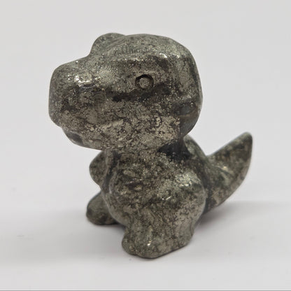 Small dinosaur figurine made of pyrite on a white background