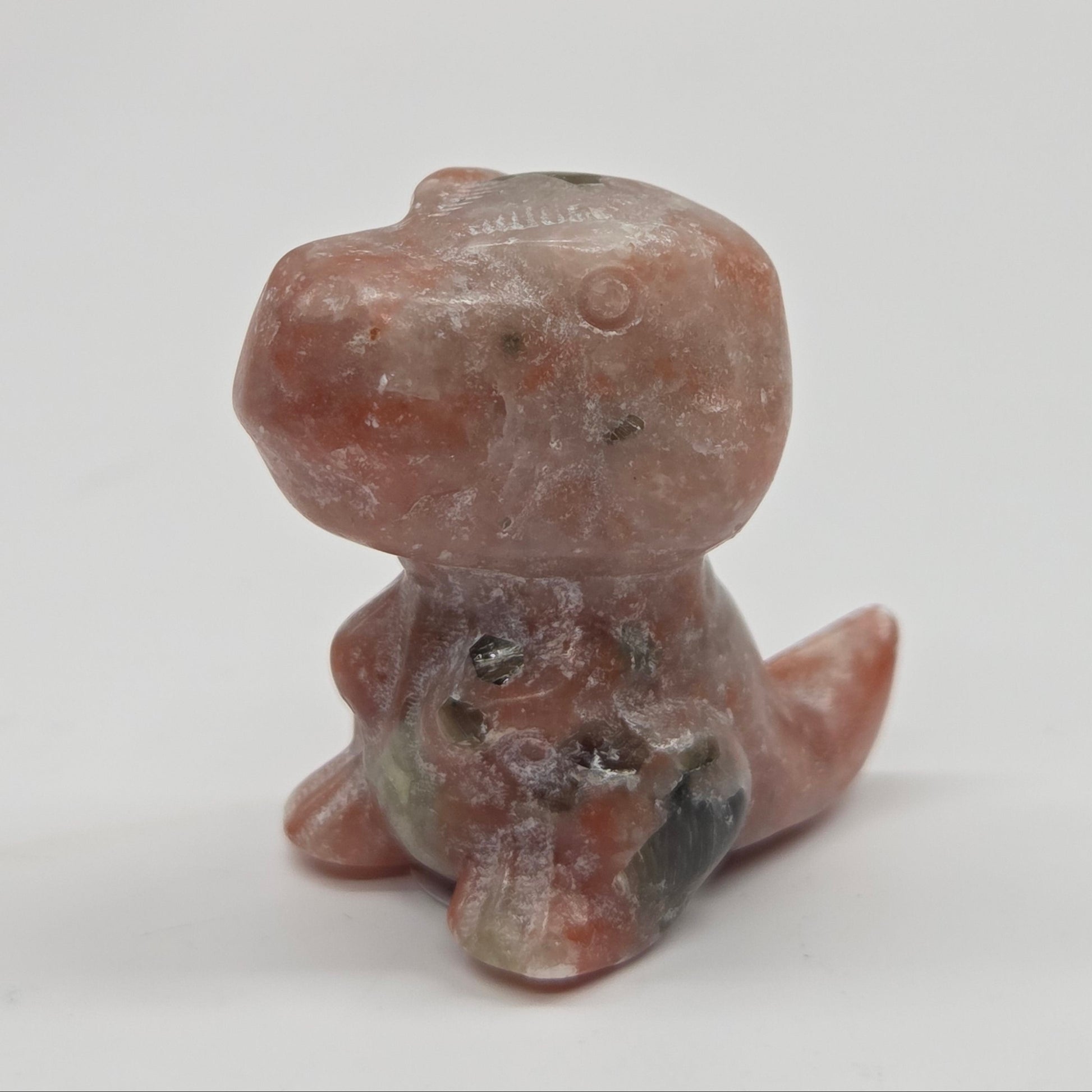 Small stone dinosaur of a creature on a white background