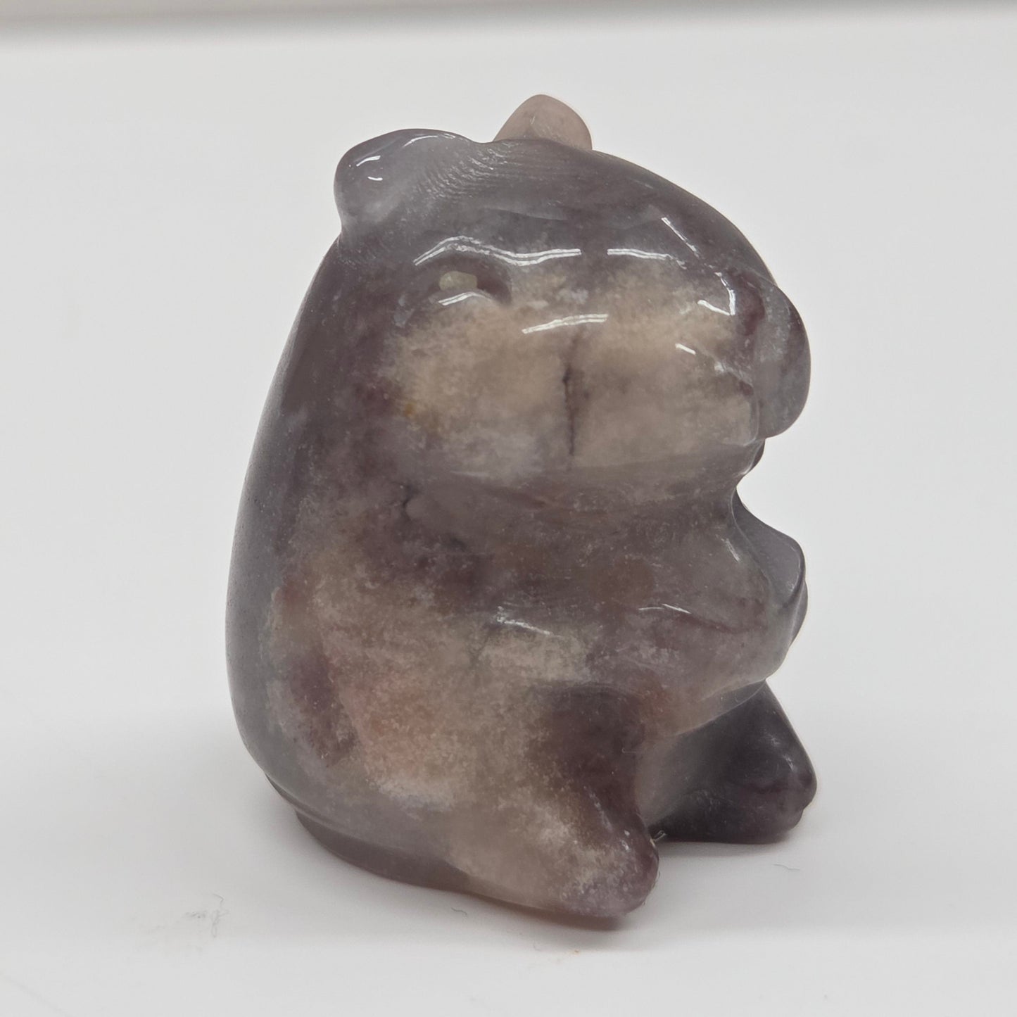 Small stone capybara figurine on a white background