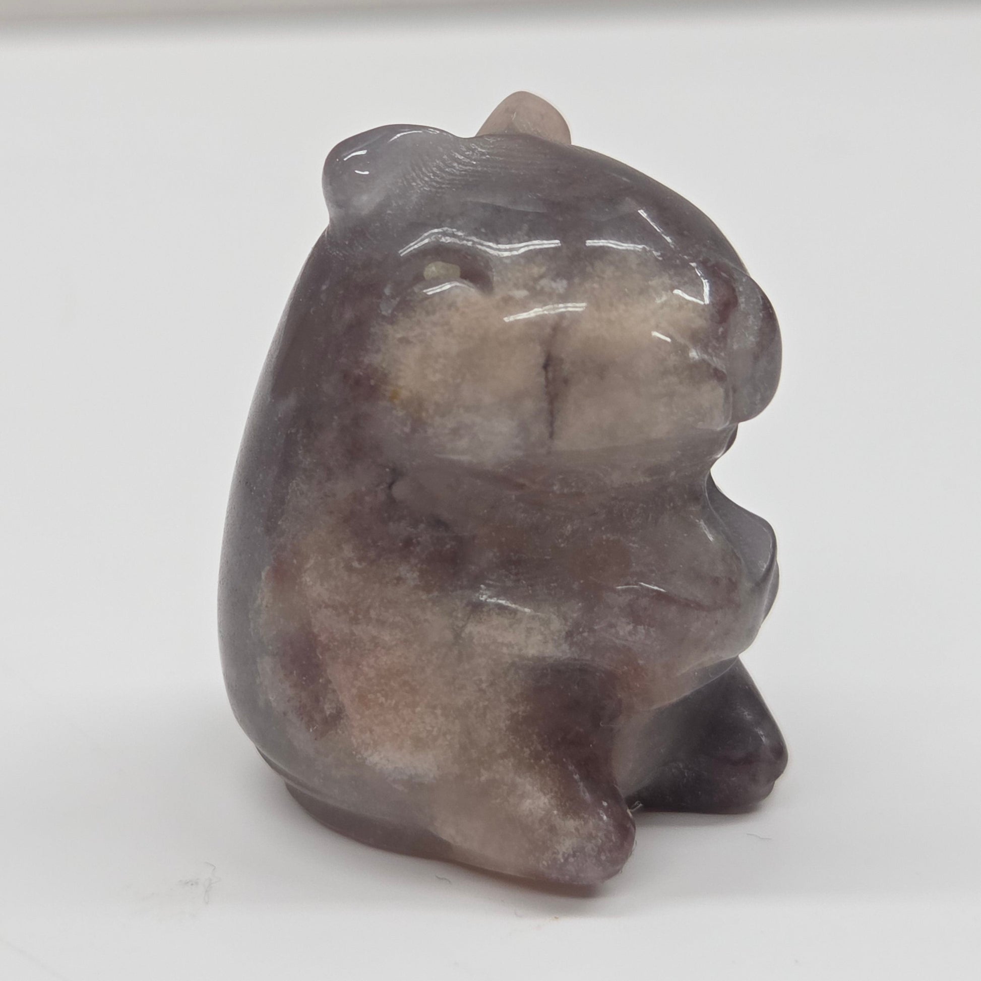 Small stone capybara figurine on a white background