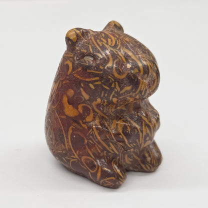 Small stone capybara figurine on a white background