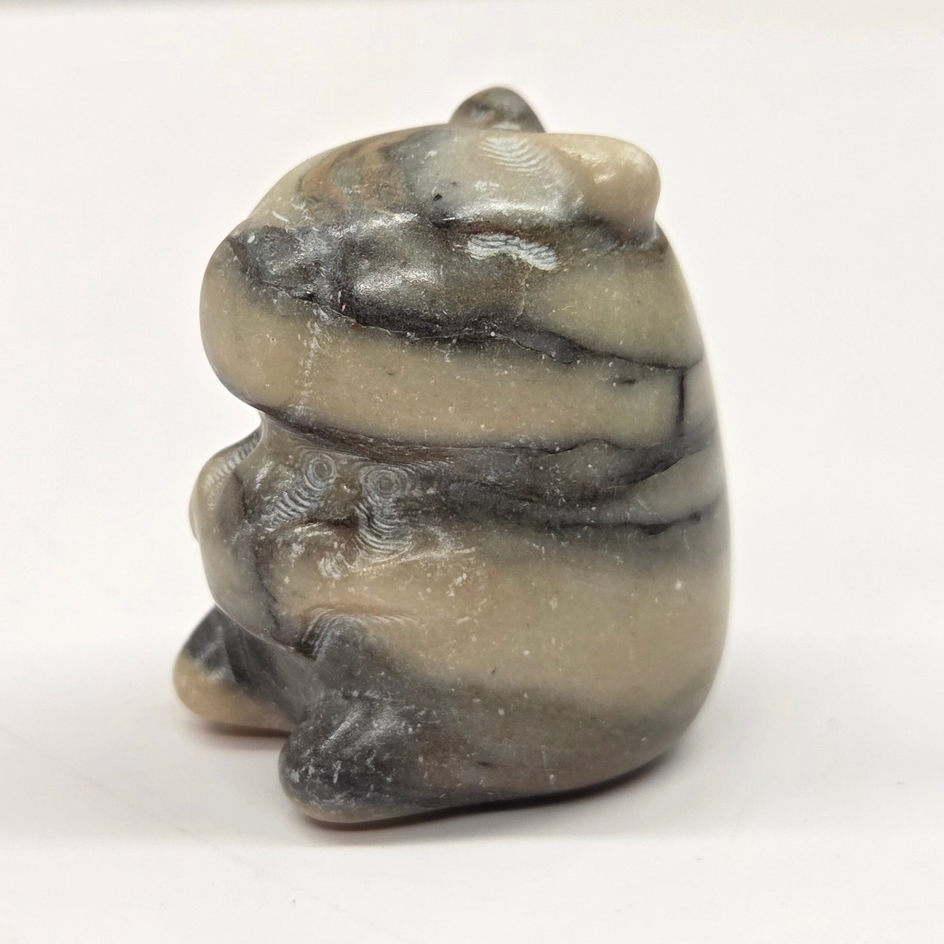 Small stone capybara figurine on a white background