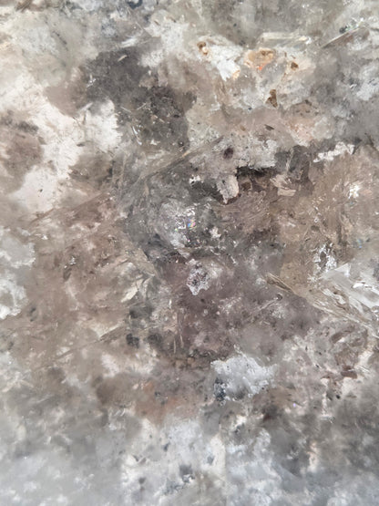 Close-up of a crystal formation with a star-like shape on a gray background