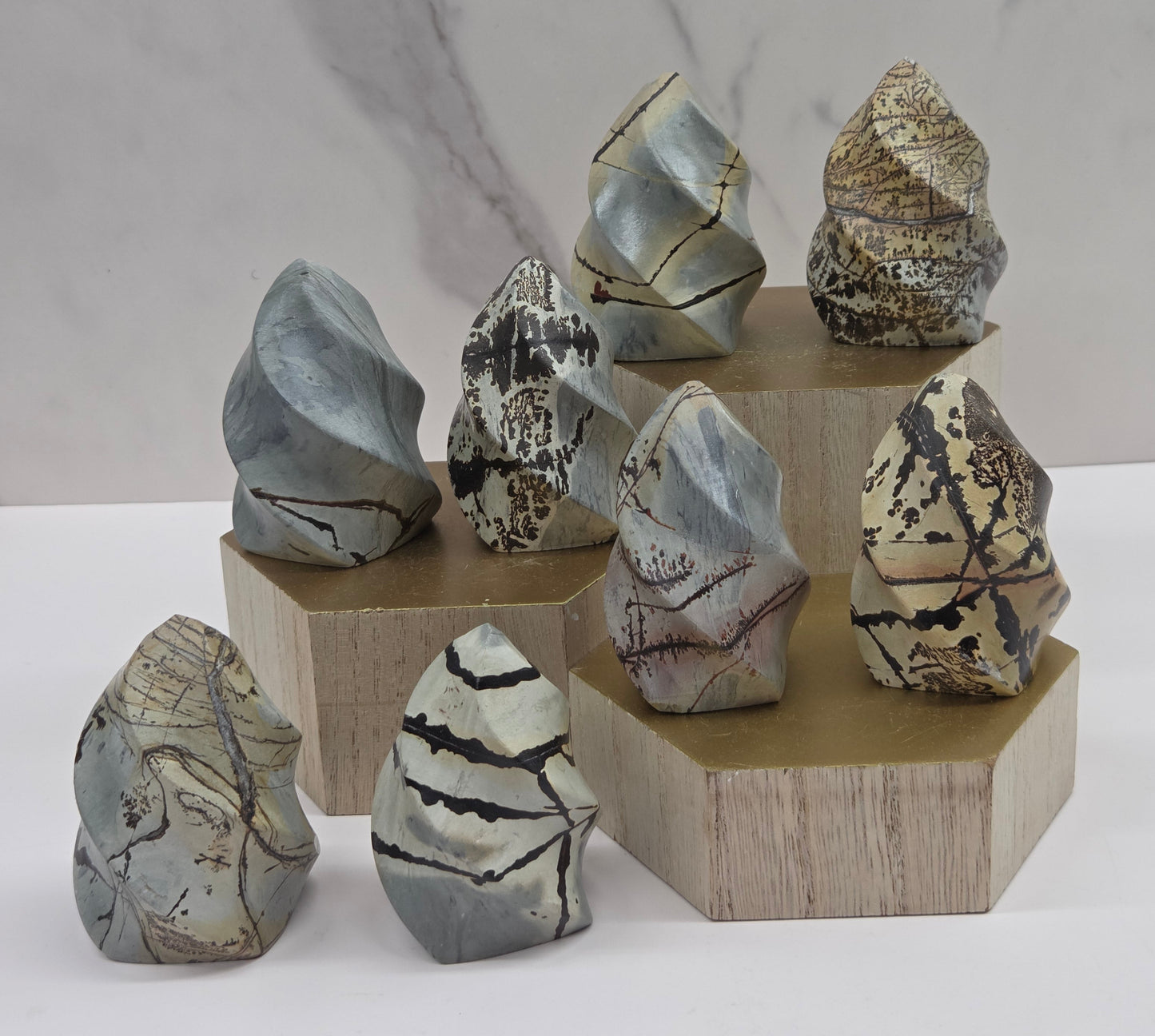 Picture Jasper carvings resembling flames on a wood stand against a neutral background