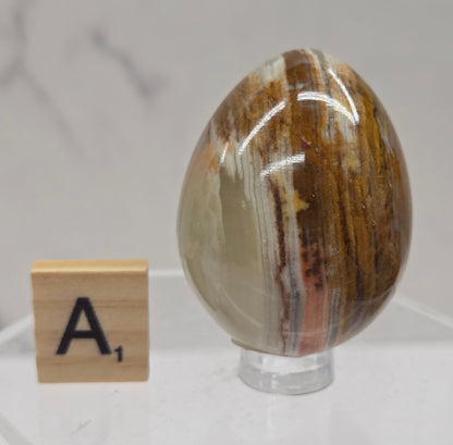 Afghan jade egg carving with green and brown bands against a neutral background