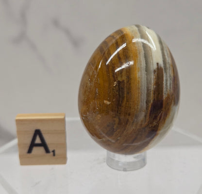 Afghan jade egg carving with green and brown bands against a neutral background
