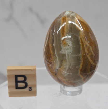 Afghan jade egg carving with green and brown bands against a neutral background