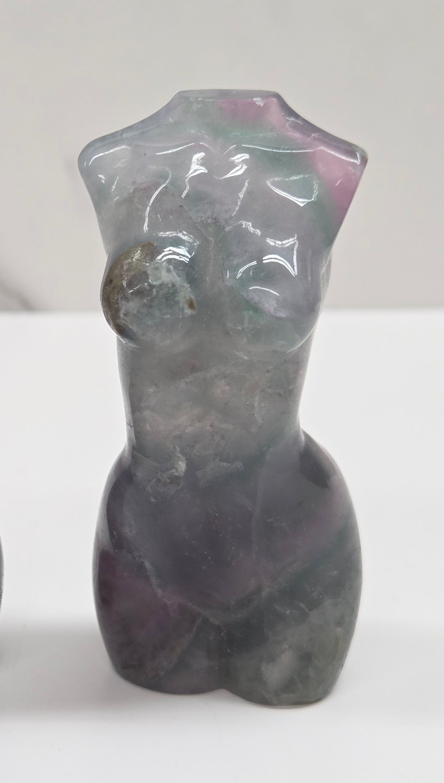 Female torso carving made of fluorite on a white background