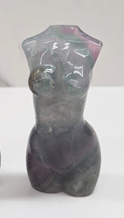 Female torso carving made of fluorite on a white background