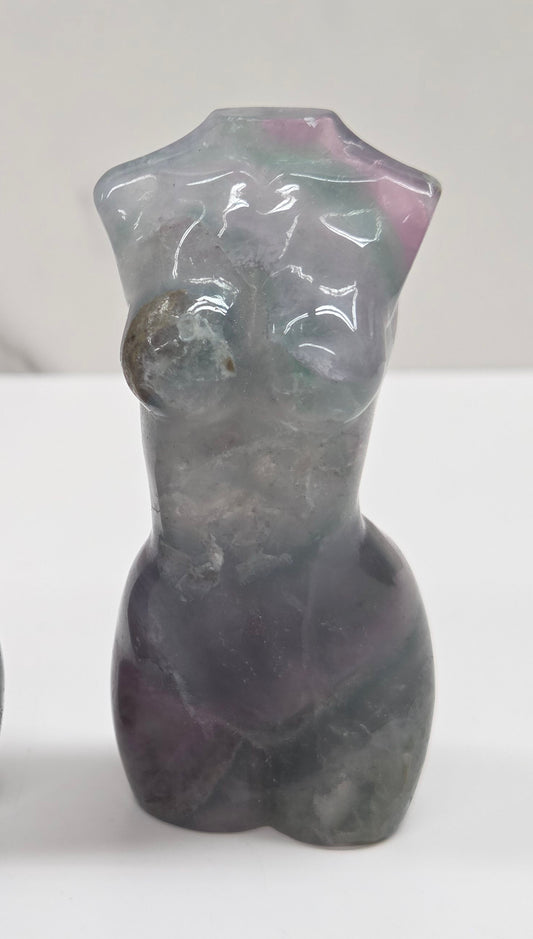 Female torso carving made of fluorite on a white background