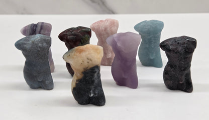 Male torso carvings made in a variety of materials and colors on a white background