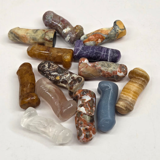 Collection of male anatomy parts in a variety of materials and colors on a white background