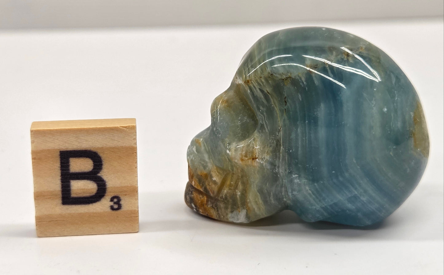 Blue and brown banded skull carving on a white background