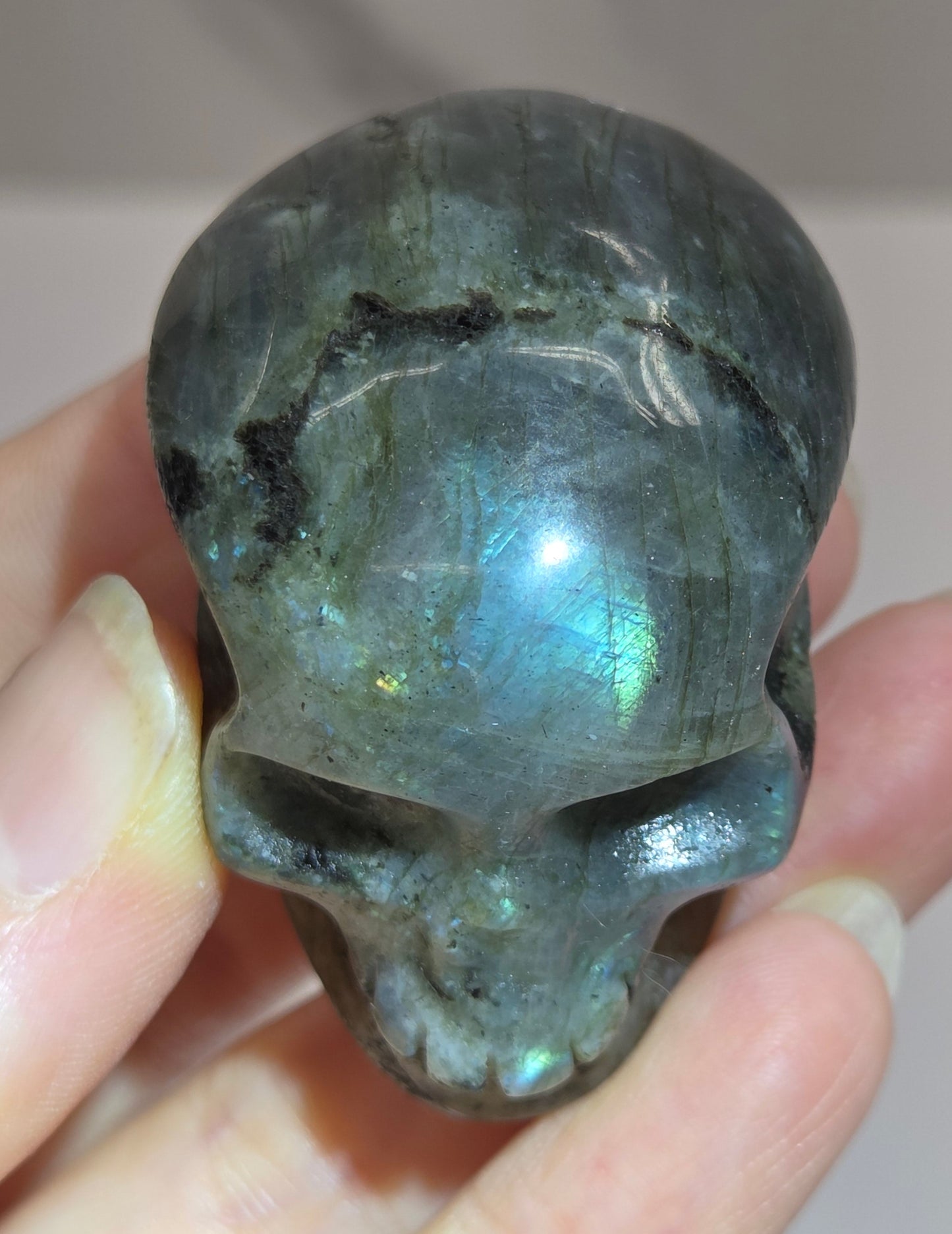 grey skull carving with blue flash on a white background