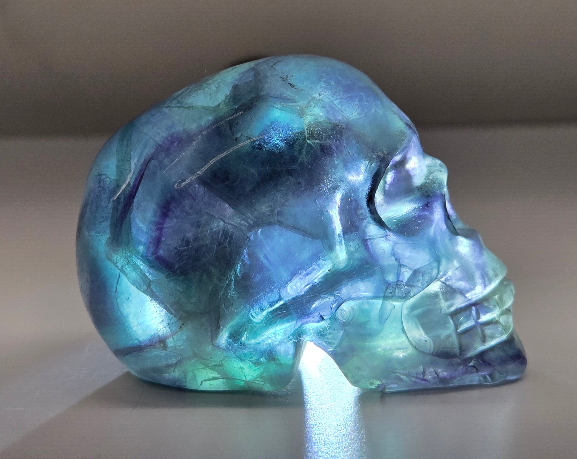 Backlit Fluorite skull carving on a white background