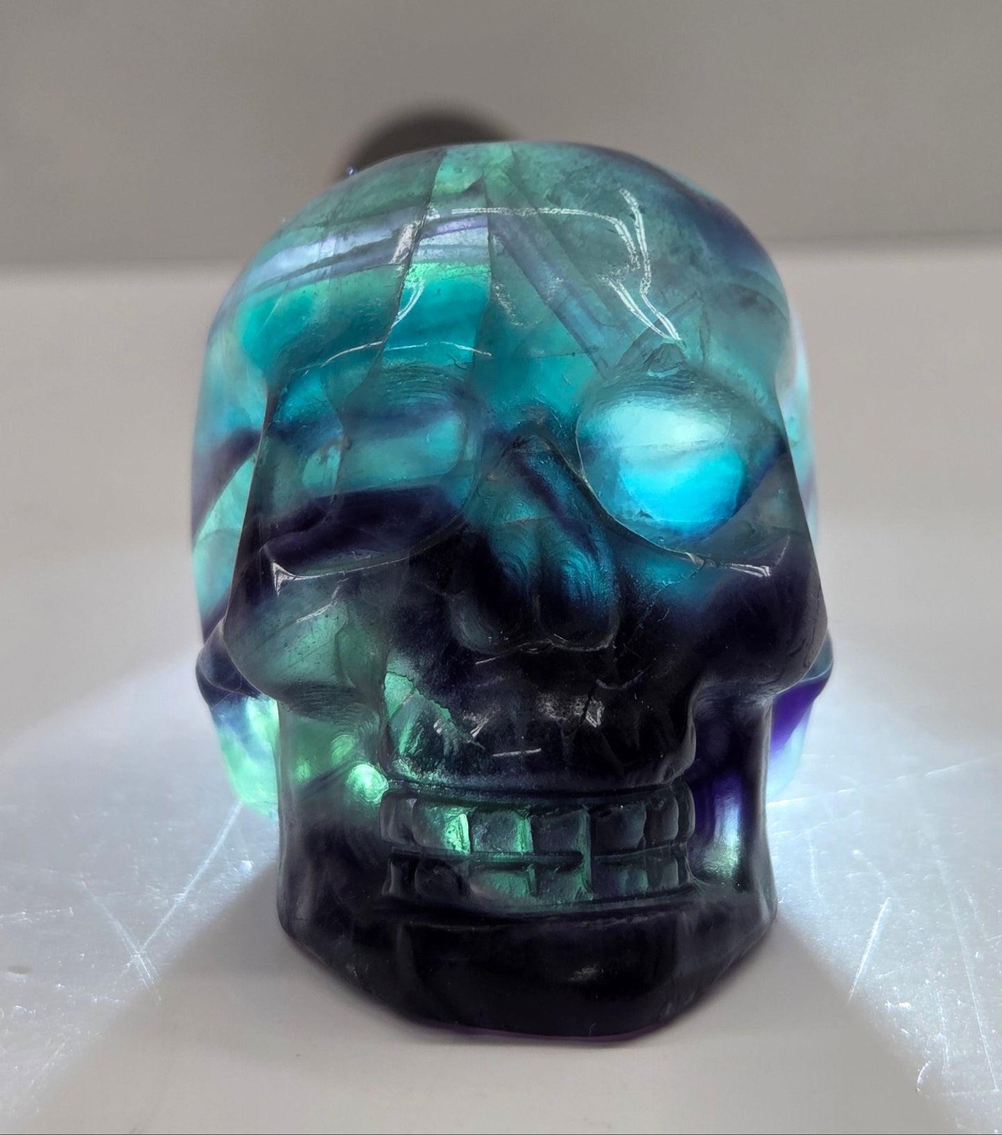 Backlit Fluorite skull carving on a white background