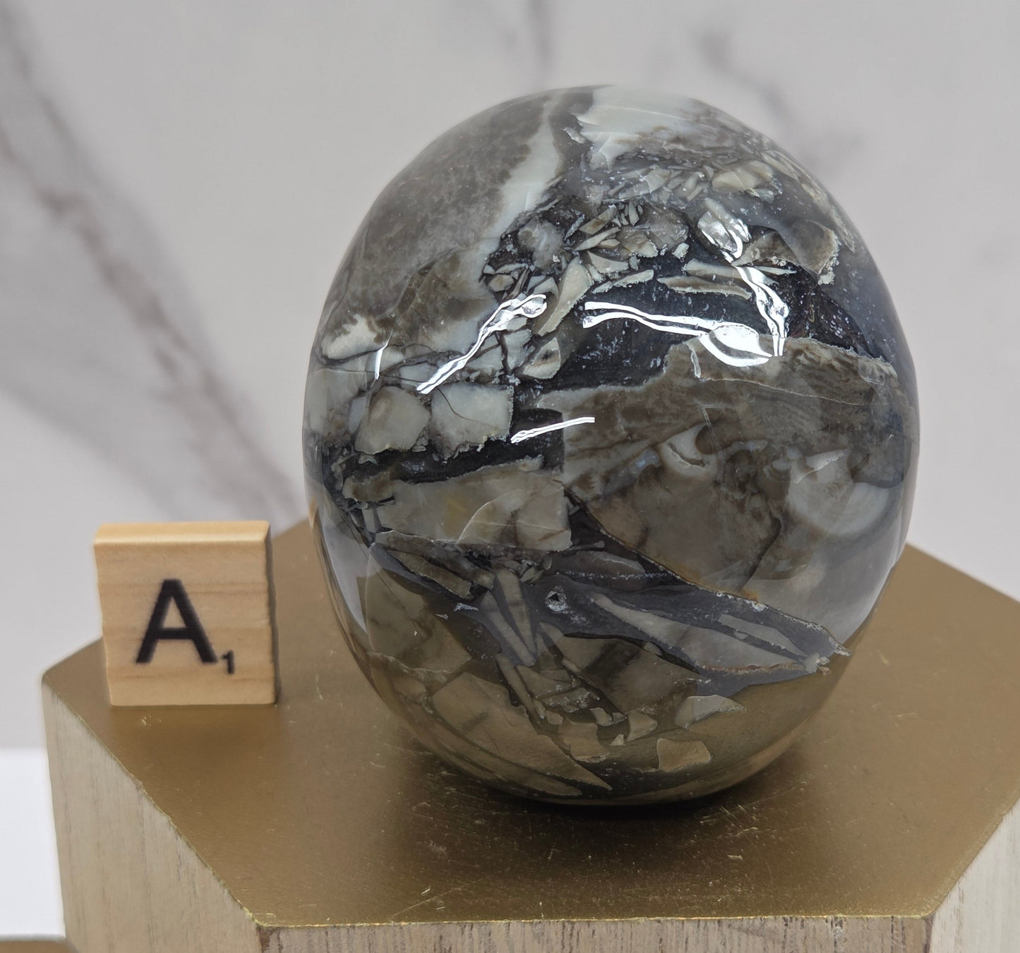 A skull-shaped sculpture made of volcano agate, displayed on wooden block