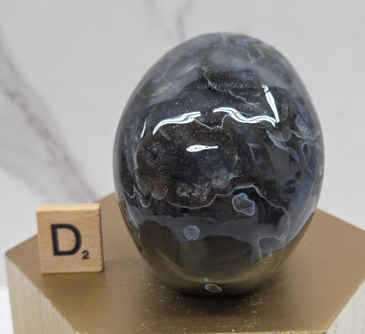 A skull-shaped sculpture made of volcano agate, displayed on wooden block