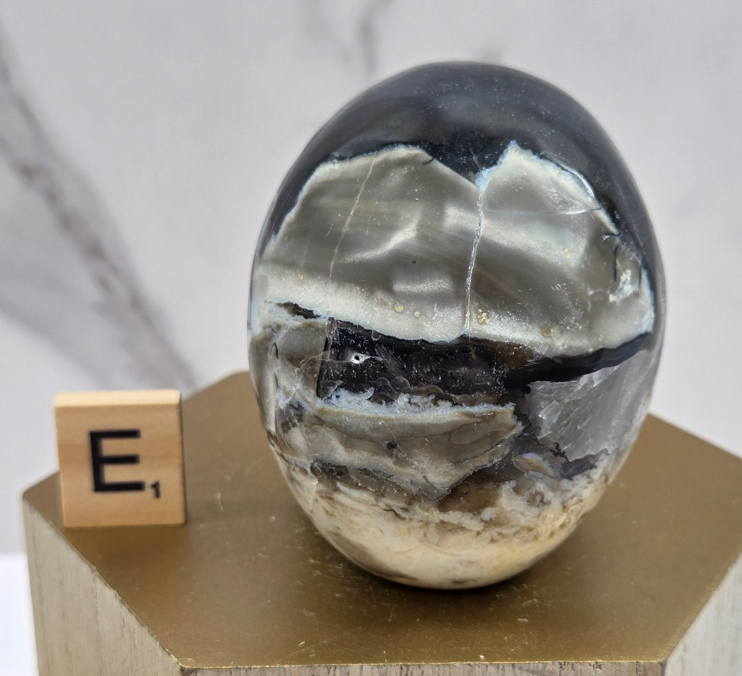 A skull-shaped sculpture made of volcano agate, displayed on wooden block