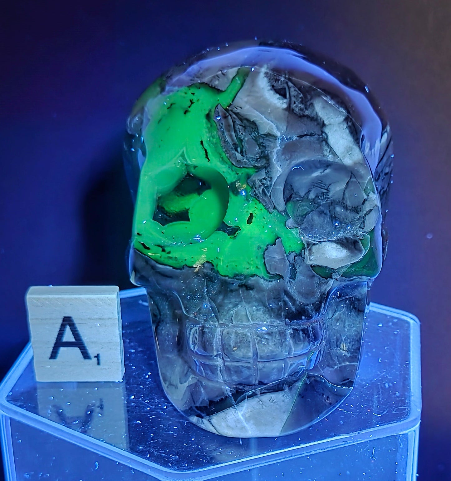 A skull-shaped sculpture made of volcano agate, under UV light