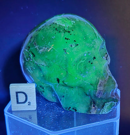 A skull-shaped sculpture made of volcano agate, under UV light