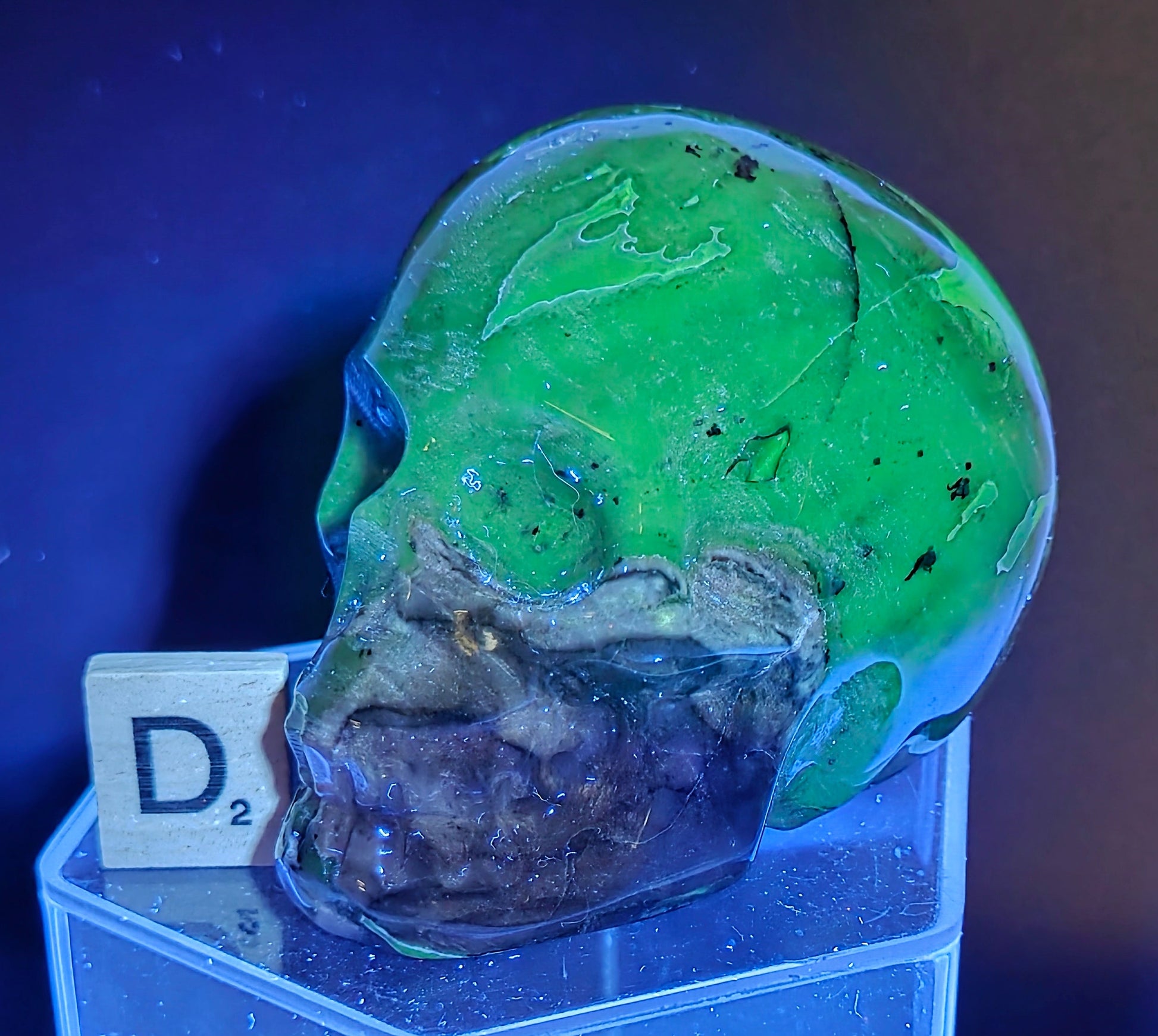 A skull-shaped sculpture made of volcano agate, under UV light