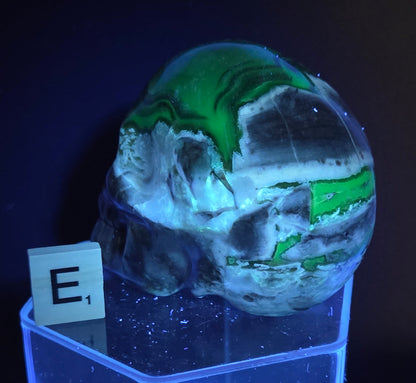 A skull-shaped sculpture made of volcano agate, under UV light