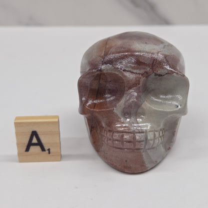 skull carving with pink and grey coloring on a white background