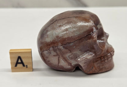 skull carving with pink and grey coloring on a white background