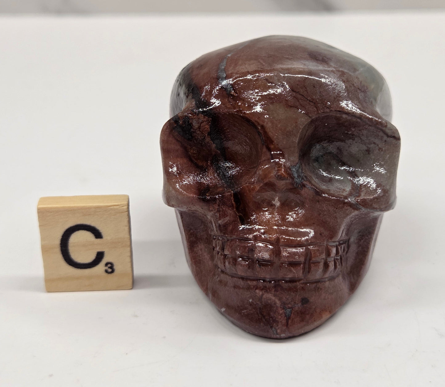 skull carving with pink and grey coloring on a white background