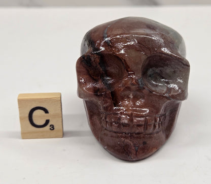 skull carving with pink and grey coloring on a white background