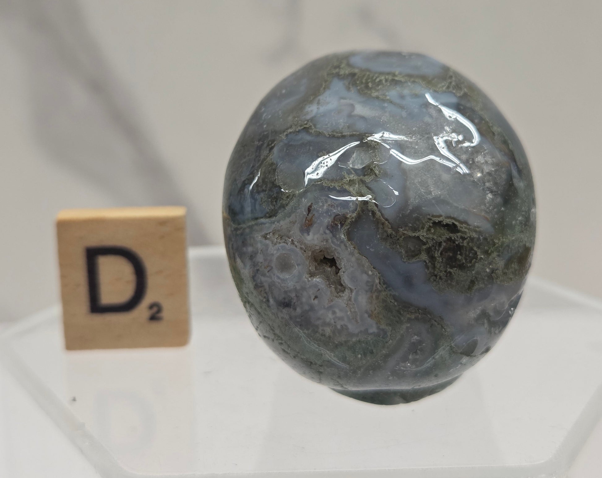 Moss Agate skull carving on a white background