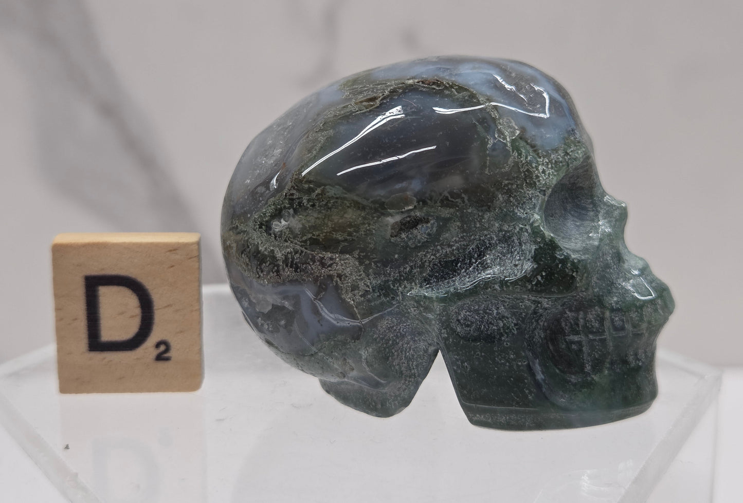 Moss Agate skull carving on a white background