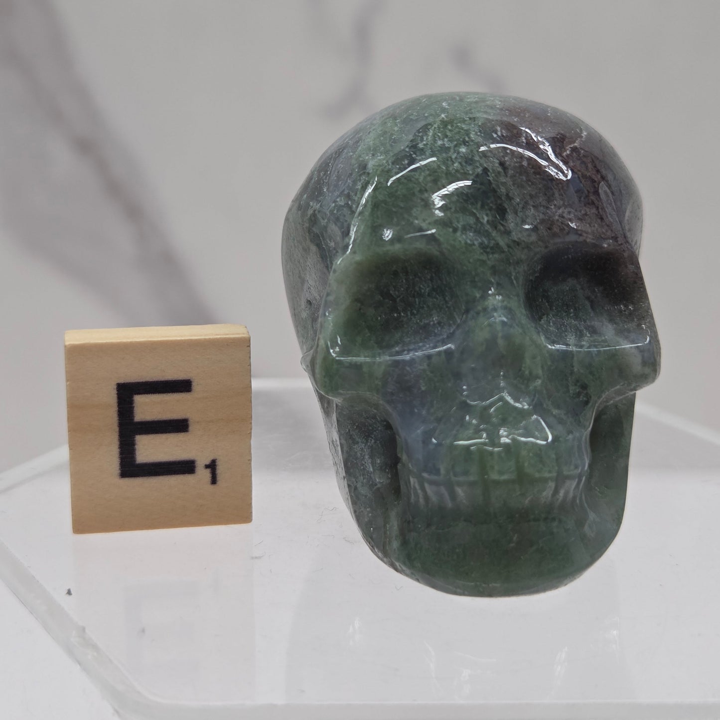 Moss Agate skull carving on a white background