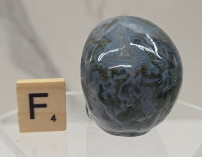 Moss Agate skull carving on a white background